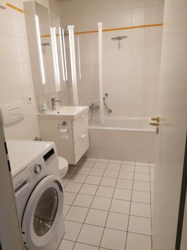 een witte badkamer met een wasmachine bij Apartment am See Bad Saarow in Bad Saarow