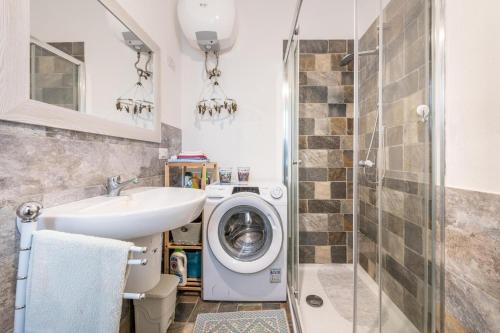 a bathroom with a washing machine and a sink at Casa a 50 passi dalla spiaggia in Capoterra