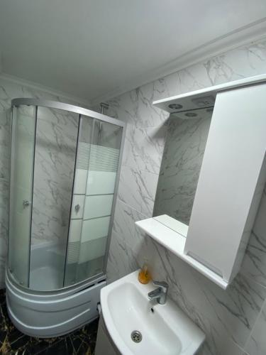 a white bathroom with a shower and a sink at Lemberg Relax House in Lviv
