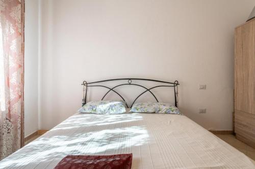 a bed with two pillows on it in a bedroom at Casa a 50 passi dalla spiaggia in Capoterra