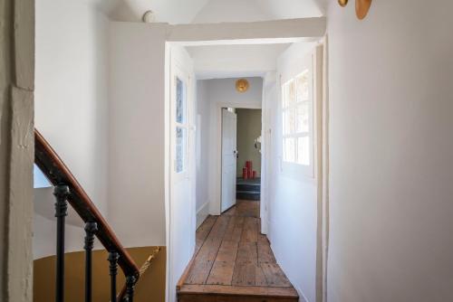 a hallway with a wooden floor and a stair case at La Maison Pavie in Dinan