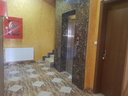a bathroom with a shower with a tile floor at Hotel LU-MA in Tbilisi City