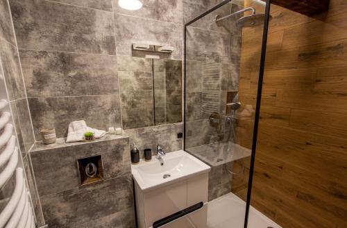 łazienka z umywalką i prysznicem w obiekcie Szymborska Apartamenty Mostowa 18-2 w Toruniu