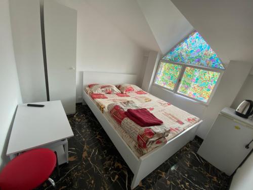 a small bedroom with a bed and a red chair at Lemberg Relax House in Lviv