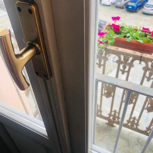 a door with a window and a table with flowers at Casa Conte Rosso in Avigliana
