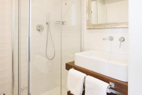 a white bathroom with a sink and a shower at Antica Locanda Leonardo in Milan