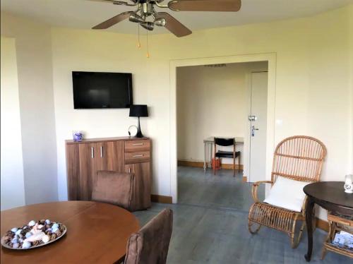 Il comprend un salon doté d'une table et d'une télévision à écran plat. dans l'établissement Appartement vue sur baie et océan, 100 m de la plage et du centre par chemin privé, à Arcachon