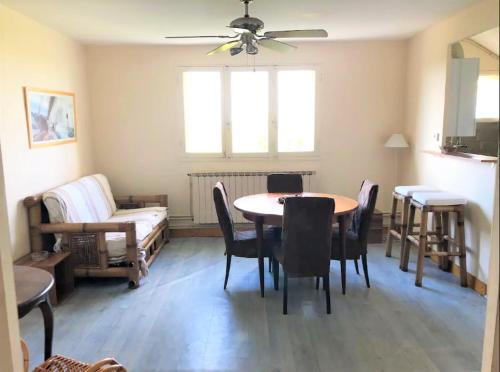 un salon avec une table, des chaises et un canapé dans l'établissement Appartement vue sur baie et océan, 100 m de la plage et du centre par chemin privé, à Arcachon
