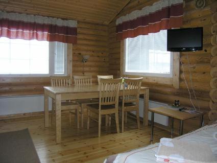 a dining room with a table and chairs in a cabin at Mertaranta in Pääjärvi