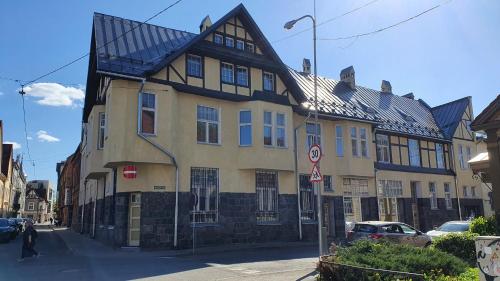 a large building with a gambrel roof on a street at Posti Apartment in Viljandi