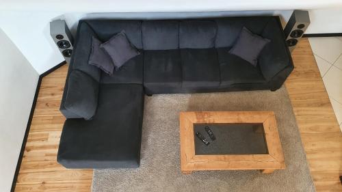 a black leather couch with pillows and a wooden table at Posti Apartment in Viljandi