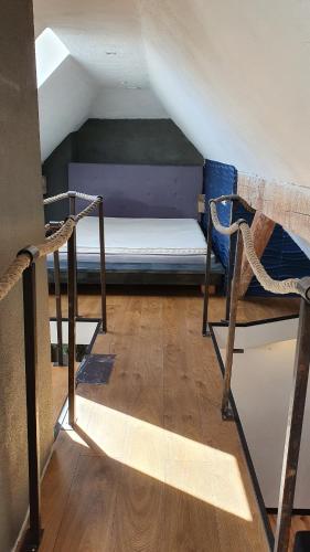 Cette chambre mansardée comprend un lit et une chaise. dans l'établissement Posti Apartment, à Viljandi
