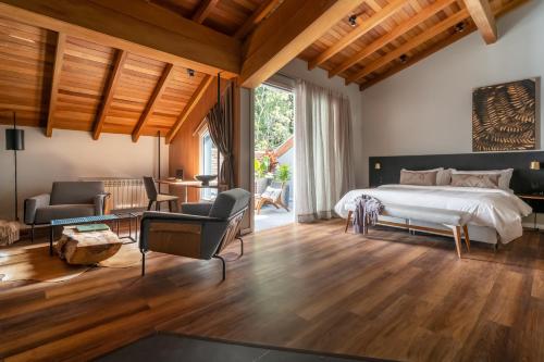 a bedroom with a bed and a living room at Jangal das Araucárias Swan Design Hotel Canela in Canela
