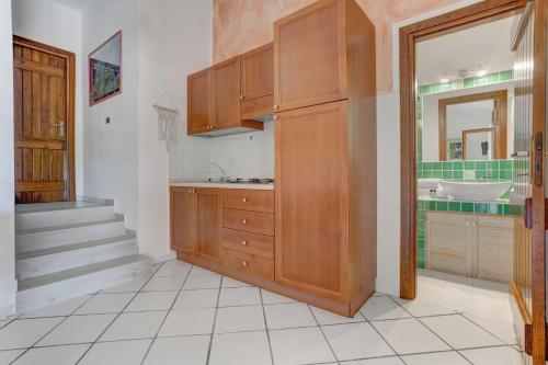 a bathroom with wooden cabinets and a sink at VILLA MARIA - CAPO D'ORSO - HOME and MORE in Palau
