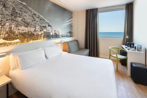 a hotel room with a bed and a view of the ocean at B&B HOTEL Alicante in Alicante