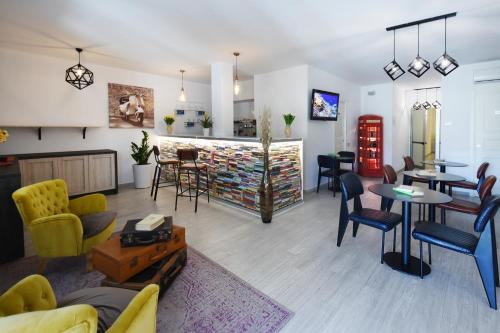een woonkamer met stoelen en tafels en een bar bij Xenia Hotel in Villasimius