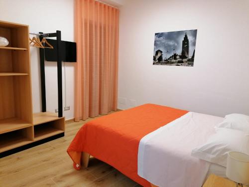 1 dormitorio con 1 cama con sábanas de color naranja y blanco en B&B Nonna Elvira, en Castelforte