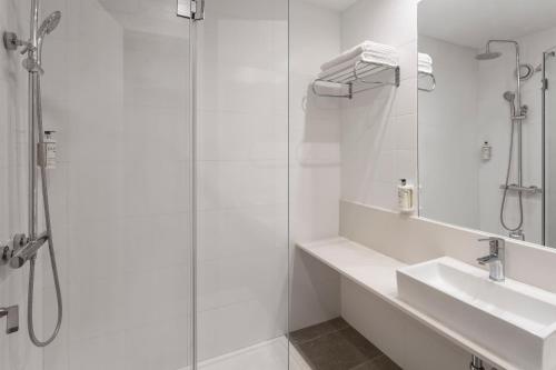 a white bathroom with a sink and a shower at B&B HOTEL Alicante in Alicante