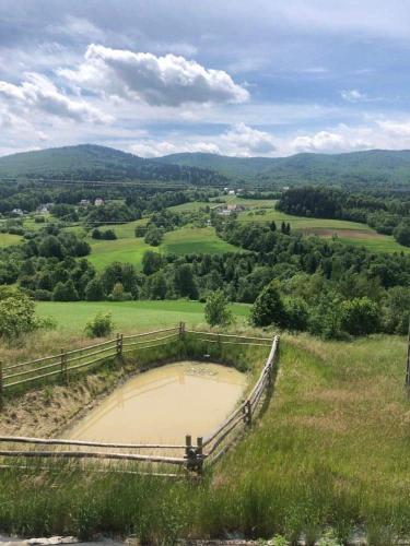a view from the top of a hill with a pond at Koperkowy Raj Beskid Wyspowy Domek Małopolska Jacuzzi Playroom in Laskowa