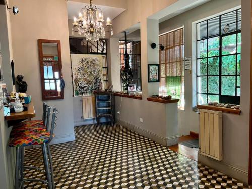 a room with a hallway with a chandelier and windows at Hosteria Casa de Paula in Trelew
