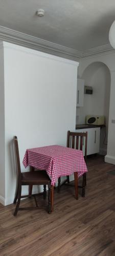 a room with a table and two chairs and a kitchen at Brynawel in Aberystwyth