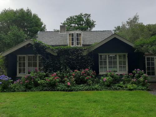 uma casa com flores em frente em Gorssels Tuinhuis em Gorssel