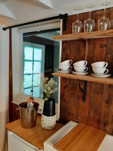 uma cozinha com prateleiras e tigelas de madeira e um lavatório em Gorssels Tuinhuis em Gorssel