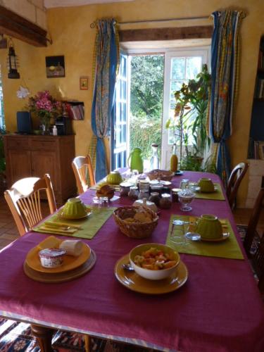a dining room table with a purple table cloth at L'Echappée Belle Périgord in Cercles