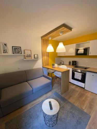 un salon avec un canapé et une table dans l'établissement Centre Saint-Gervais studio Jaune moderne proche télécabine 2 pers, à Saint-Gervais-les-Bains