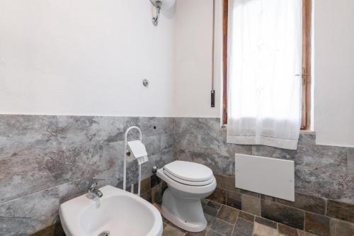 a bathroom with a toilet and a sink at Casa a 50 passi dalla spiaggia in Capoterra