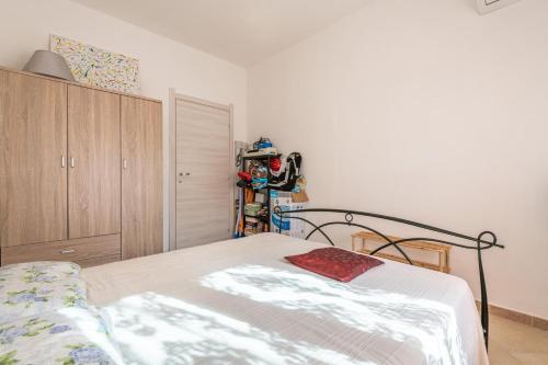 a bedroom with a bed and a wooden cabinet at Casa a 50 passi dalla spiaggia in Capoterra