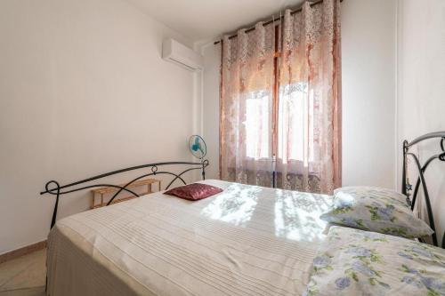 a bedroom with a bed and a window at Casa a 50 passi dalla spiaggia in Capoterra