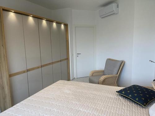 a bedroom with a white bed and a chair at Luce del Sole in Montepaone Lido