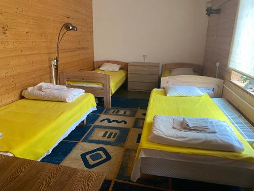 drie bedden in een kamer met gele lakens bij Anna Bed & Breakfast in Kallaste