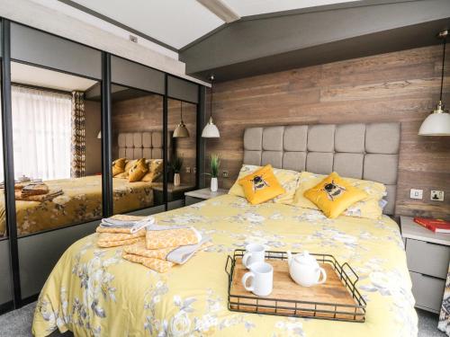 a bedroom with a large yellow bed with yellow pillows at Red Kite Lodge in Crieff