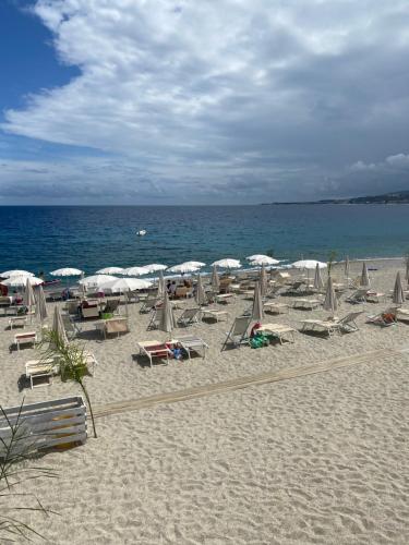 a beach with chairs and umbrellas and the ocean at Luce del Sole in Montepaone Lido