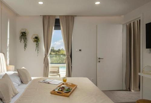 Un dormitorio con una cama con una bandeja de comida. en Villa Coralis With Heated Pool, en Vrsi