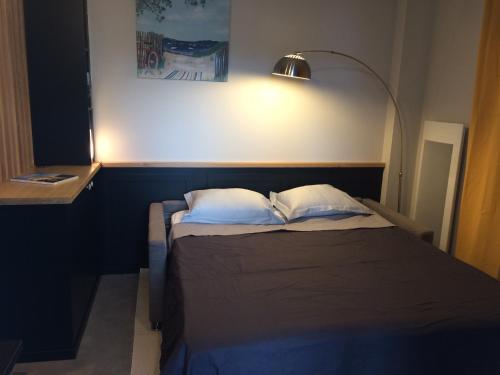 1 cama con 2 almohadas y lámpara en la parte superior en Dinard: studio à 100 m de la plage de L'Ecluse en Dinard