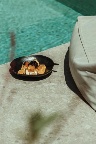 a plate of food on a table next to a pool at Asterion Suites & Spa - Designed for Adults in Gerani Chanion