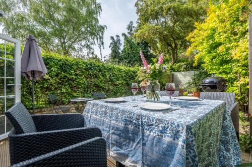 a table with glasses of wine on a patio at Adorable cottage with a log burner in heavenly village - Constable Lodge in Nayland