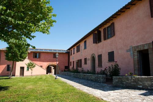 um edifício com um jardim de relva em frente em Residence Maria Giulia em Corciano