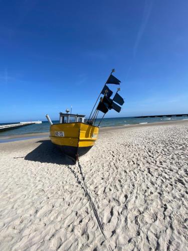 a yellow boat sitting on the beach at Relax Planet in Rewal