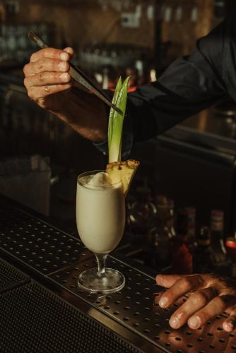 a bartender making a drink in a martini glass at Asterion Suites & Spa - Designed for Adults in Gerani Chanion