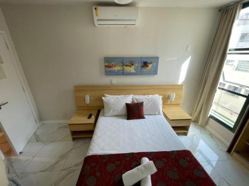 Schlafzimmer mit einem großen Bett mit roter und weißer Bettwäsche in der Unterkunft Studio na Praia de Camburi in Vitória