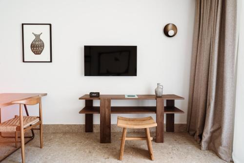 a living room with a table and a tv at Asterion Suites & Spa - Designed for Adults in Gerani Chanion