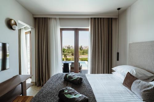 a hotel room with a bed and a large window at Asterion Suites & Spa - Designed for Adults in Gerani Chanion
