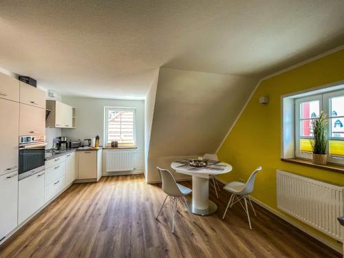 a kitchen with a table and chairs in a room at Altwernigeröder Apparthotel in Wernigerode