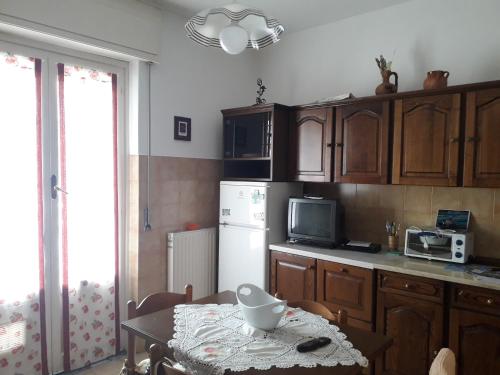 a kitchen with a table and a white refrigerator at La casa di Alice e Matteo in Casarza Ligure