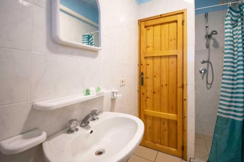 a bathroom with a sink and a wooden door at Camping Linus in Marina di Massa