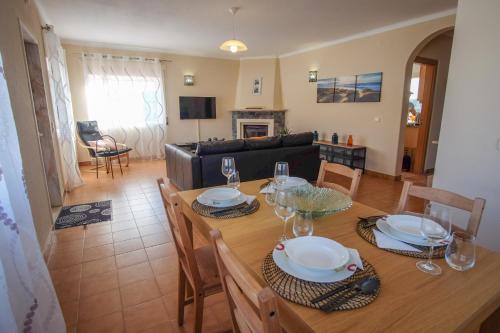 a dining room and living room with a table and chairs at Casa Madeira in Burgau